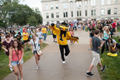 Herky leads the crowd from the Pentacrest to the President's Residence for the annual post-Convocation block party.
