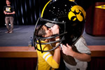 A couple poses in the oversized football helmet at the Hawkeye Huddle. The helmet was later auctioned for charity.