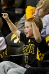 A young basketball fan cheers on the Hawkeyes during the men’s season finale with Northwestern. Iowa lost the game 70-66.