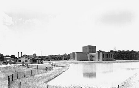 With the Theatre Building in the background, view of the skating lagoon looking southwest, with the shelter house to the left, 1940s