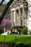 Students stroll past Schaeffer Hall framed by the expertly manicured grounds of the Pentacrest.